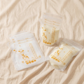 BPA-free breast milk storage bags with giraffe print laid flat on cream linen