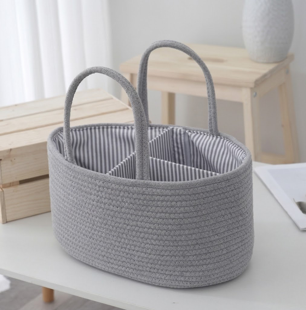 Grey cotton rope diaper caddy organiser with striped interior on white table