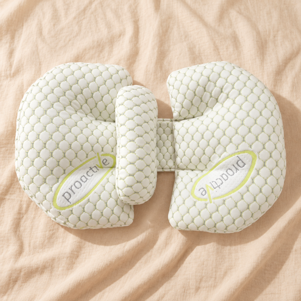 Adjustable U-shaped pregnancy support pillow in soft white quilted fabric on cream linen