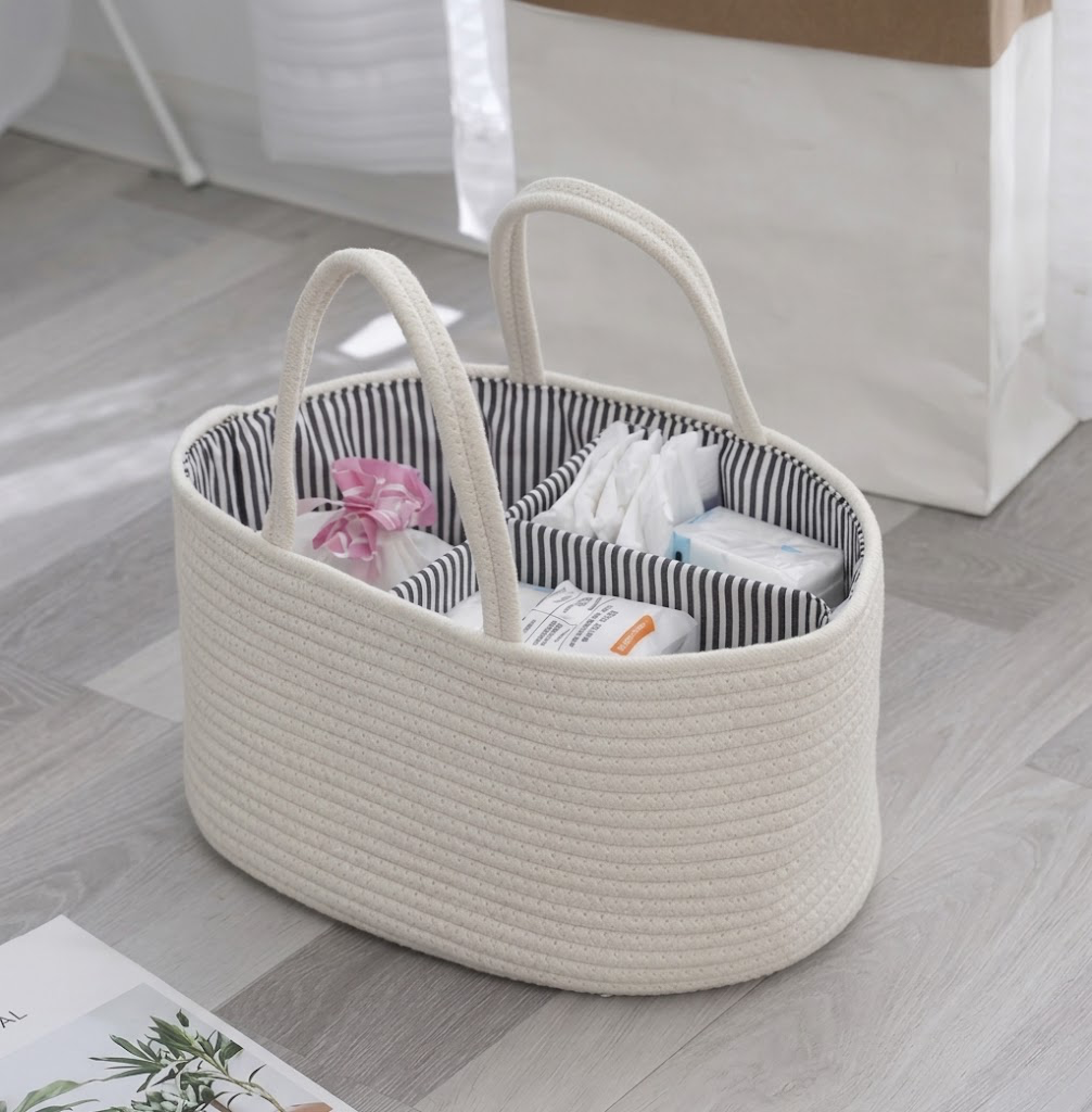 Cream cotton rope diaper caddy organiser filled with nappy essentials on floor