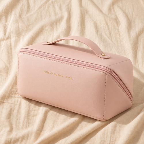 Pink leather cosmetic bag with gold hardware and handle on cream linen